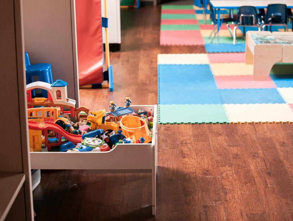 Child-friendly classroom with toys and play mats at Basic Model School