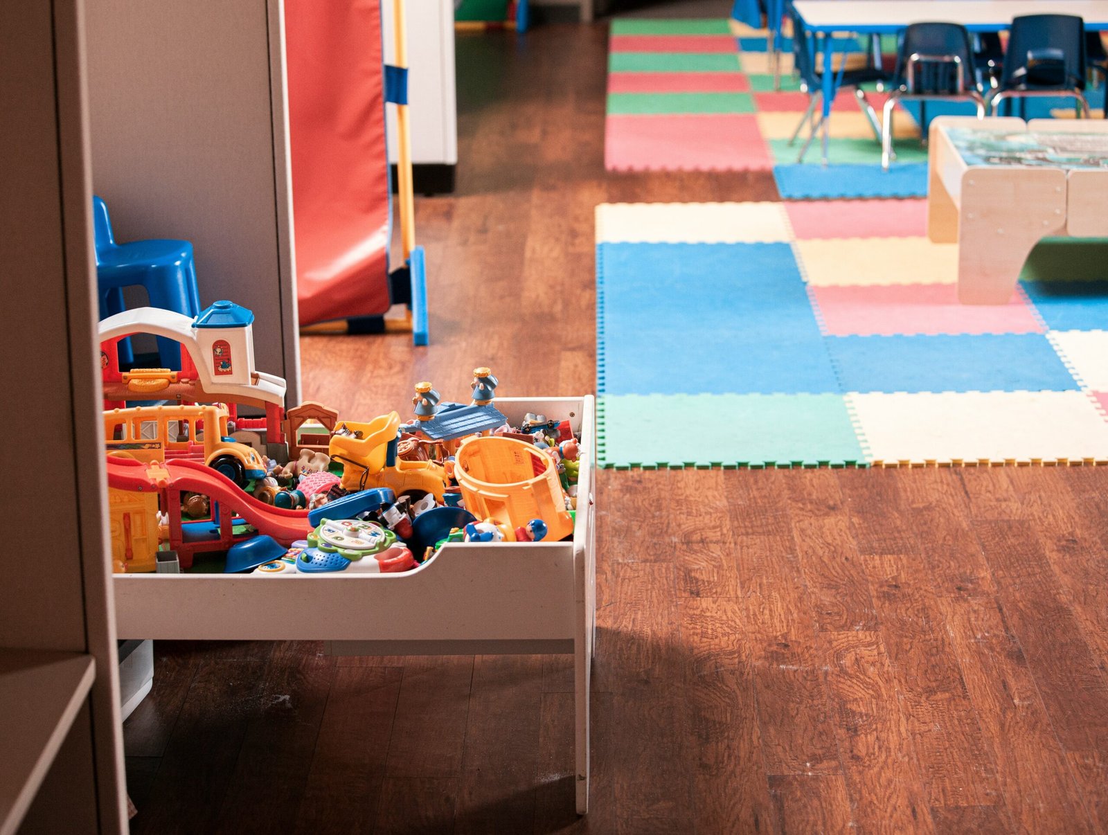 Child-friendly classroom with toys and play mats at Basic Model School