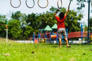 Child developing motor skills through outdoor play at Basic Model School playground